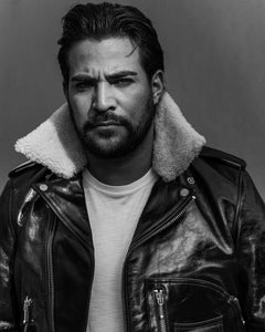 Lifestyle photo of a man modeling the Dawson black leather jacket, showcasing the fit and glossy finish of the coat.